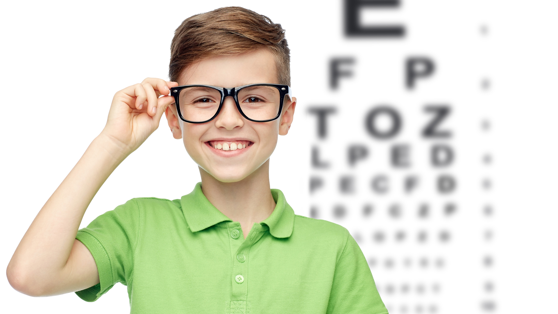 happy boy in eyeglasses over eye chart