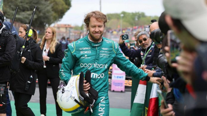 Sebastian-Vettel-carrying-helmet-planetF1